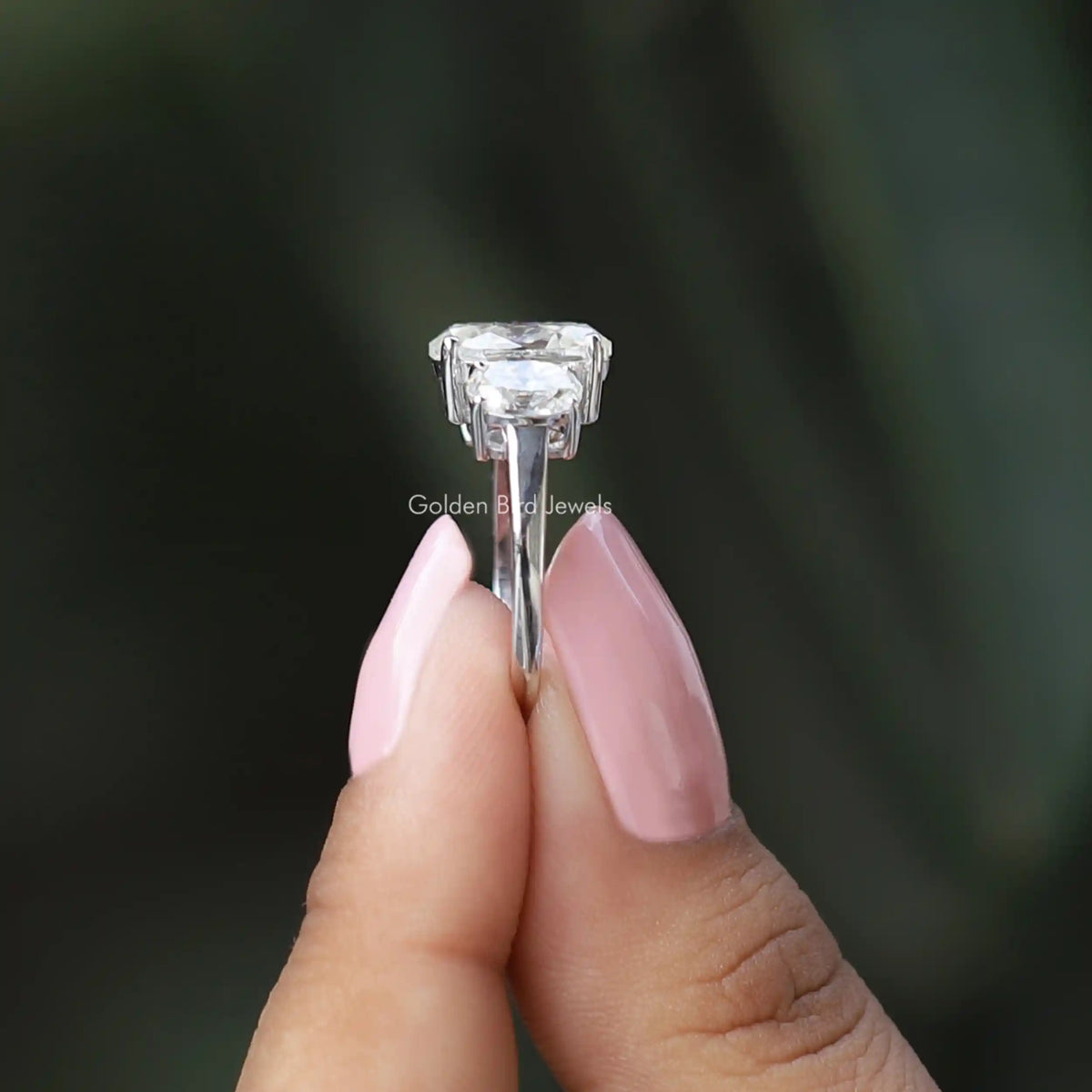 Side View of Moissanite Oval Cut 3 Stone Engagement Ring In two fingers