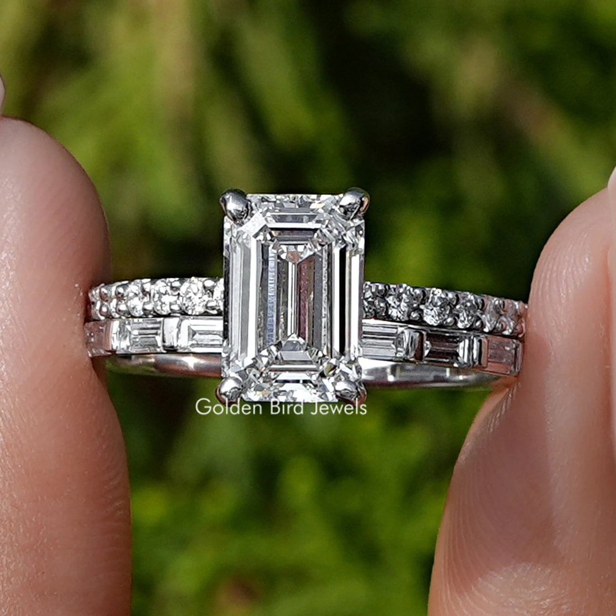 Lab Grown Diamond Emerald Cut Bridal Ring Held Between Fingers