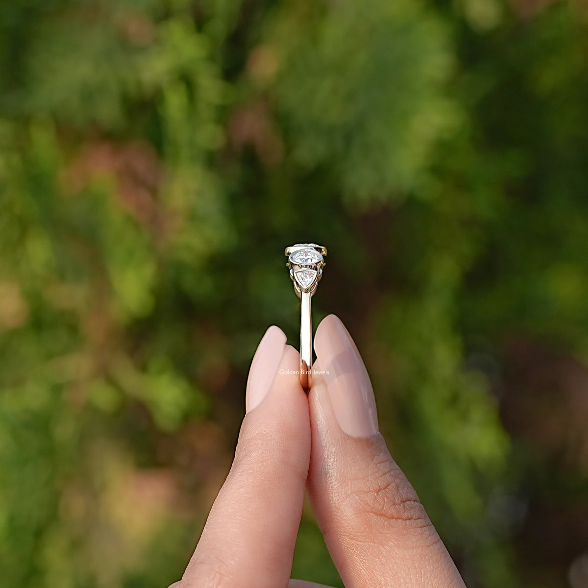 Side View of Bezel Set Round Cut Lab Diamond Five Stone Ring In two fingers