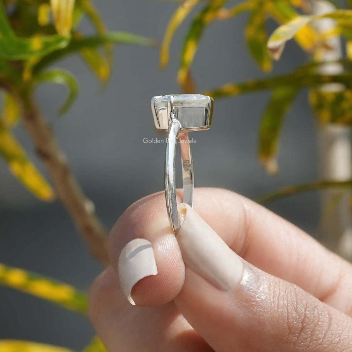 Side View of A Calf's Head Cut Moissanite Solitaire Ring In Two Fingers