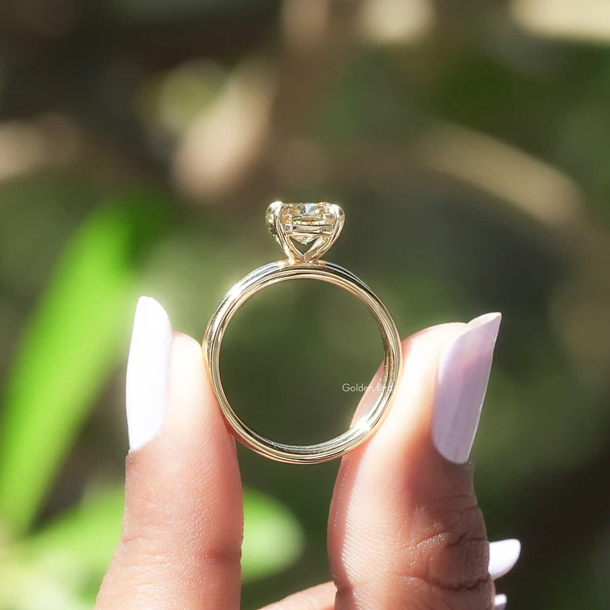 Back view of cushion cut moissanite ring on holding two fingers