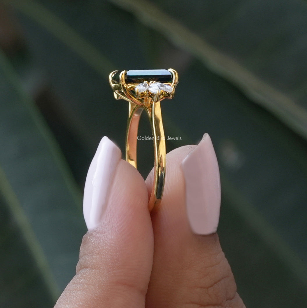 Side View of Dark Green Emerald And Marquise Cut Ring In two fingers