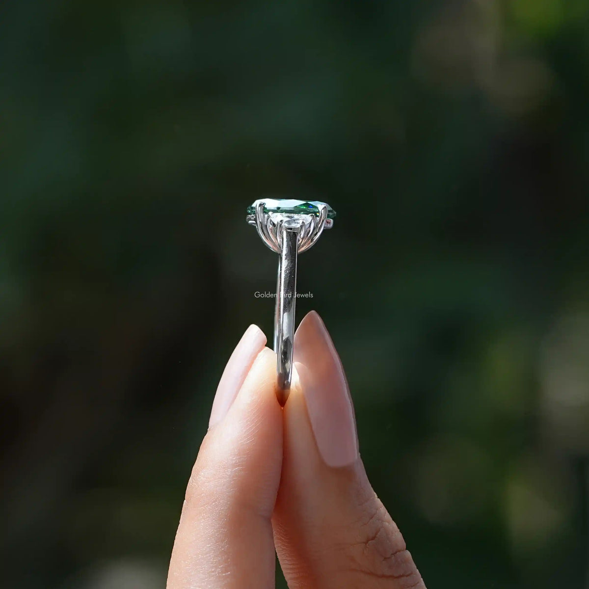 Side View of Oval Cut Moissanite Three Stone Ring In two fingers