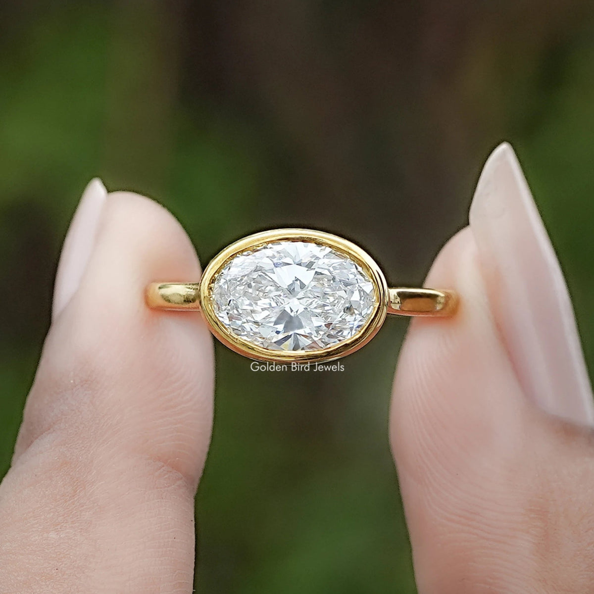East West Oval Cut Lab Diamond Bezel Set Ring In Two Fingers
