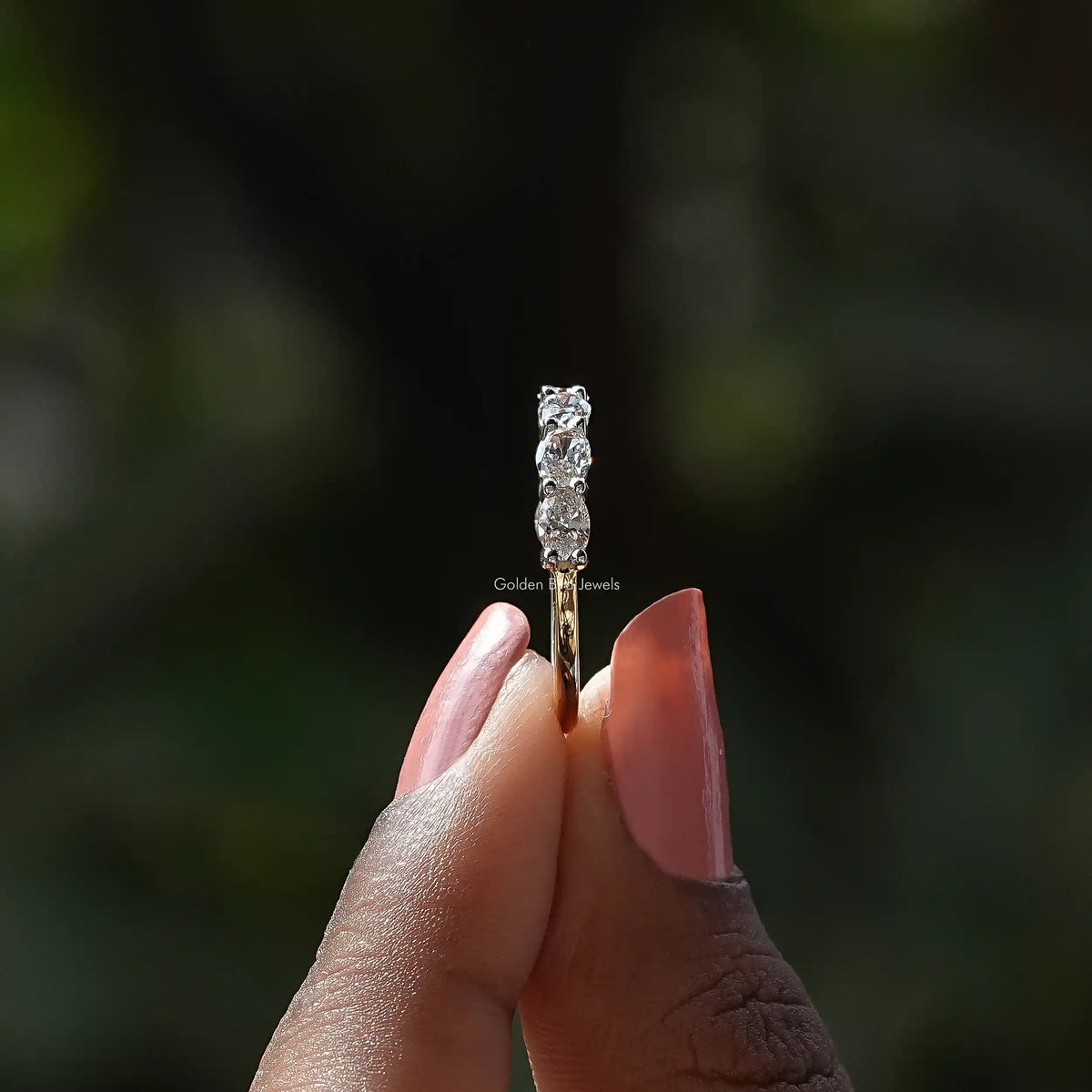 Side View of Oval Cut Lab Diamond Eternity Wedding Band In two fingers