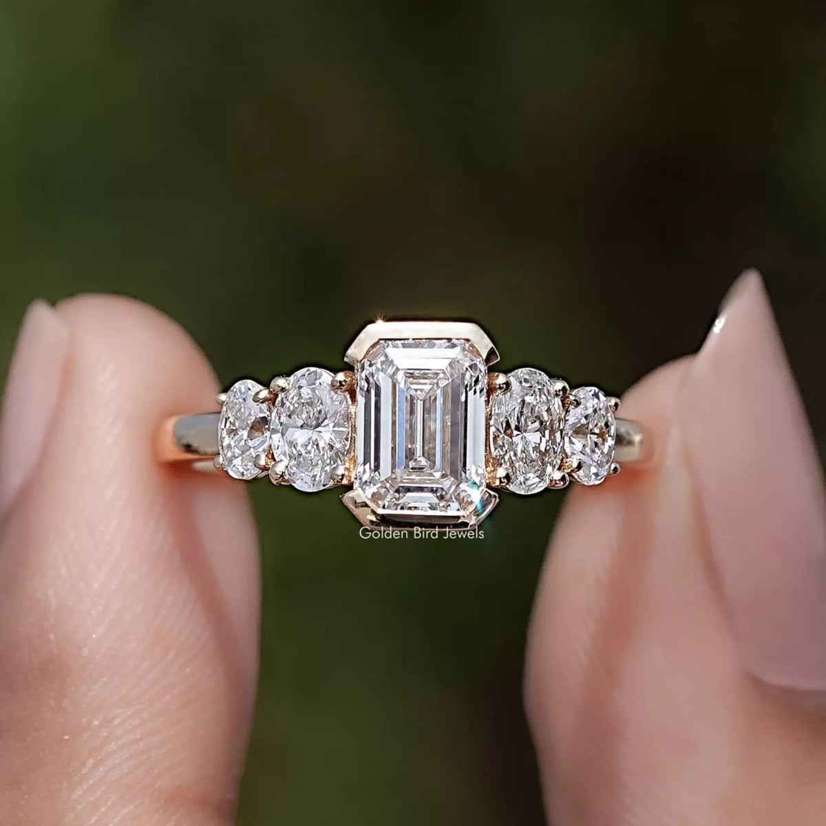 Pear And Baguette Cut Lab Diamond Five Stone Ring Between Two Fingers