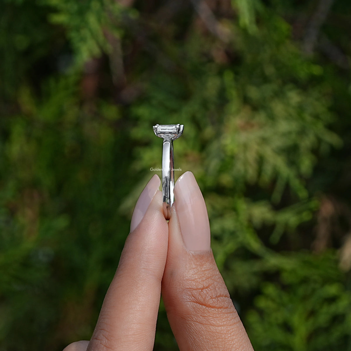 Side View of Emerald And Pear Lab Diamond Toi Et Moi Ring In two fingers