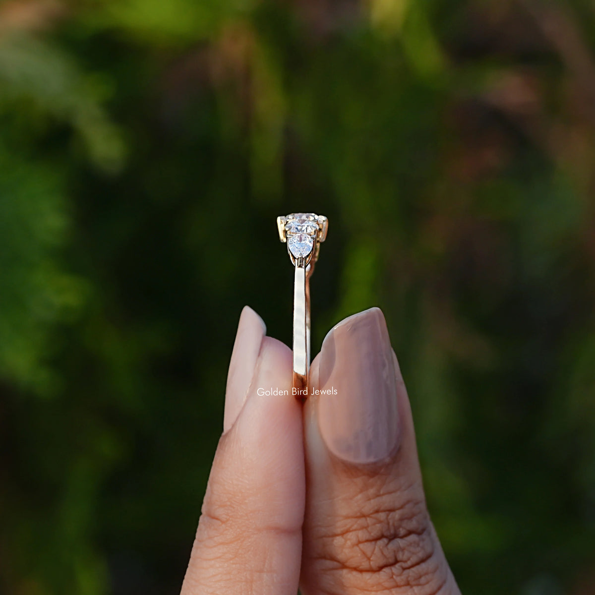 Side View of Round And Pear Lab Diamond Ring In two fingers