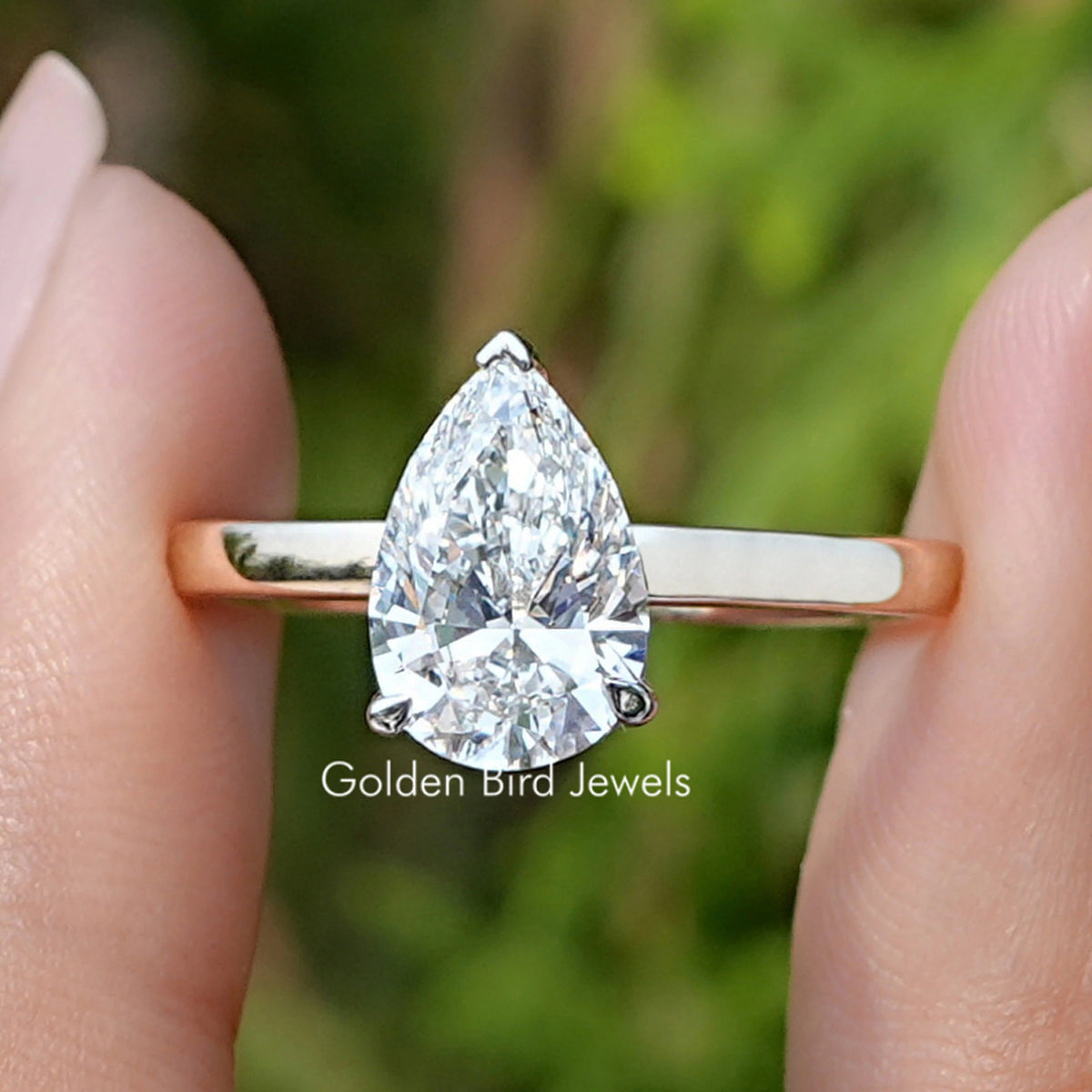 Pear Cut Lab Diamond Solitaire Ring Held Between Fingers