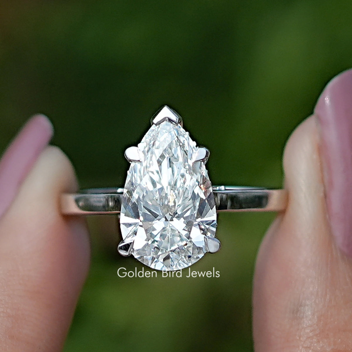 Pear Cut Halo Diamond Bridge Accent Wedding Ring Held Between Fingers