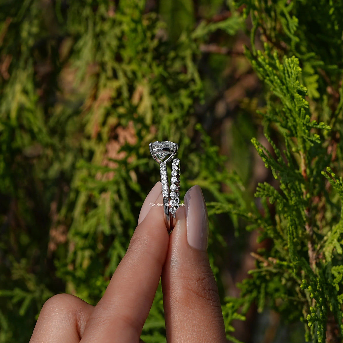 Side View of A Heart Shaped Diamond Bridal Ring Set In two fingers
