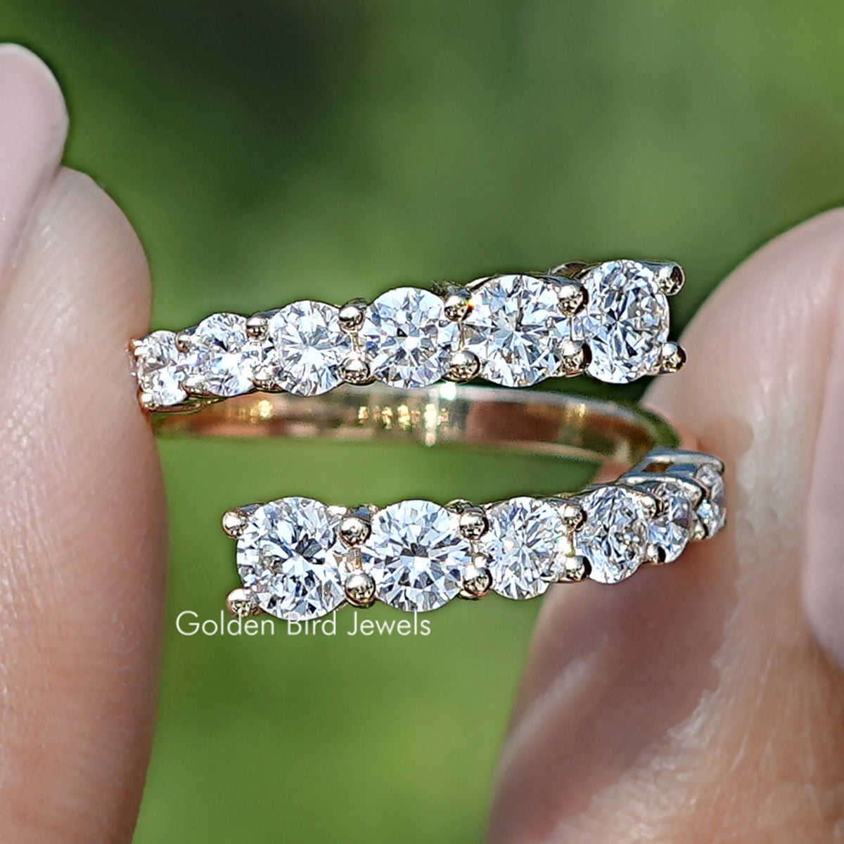 Round Cut Lab Diamond Bypass Wedding Band Held Between Fingers