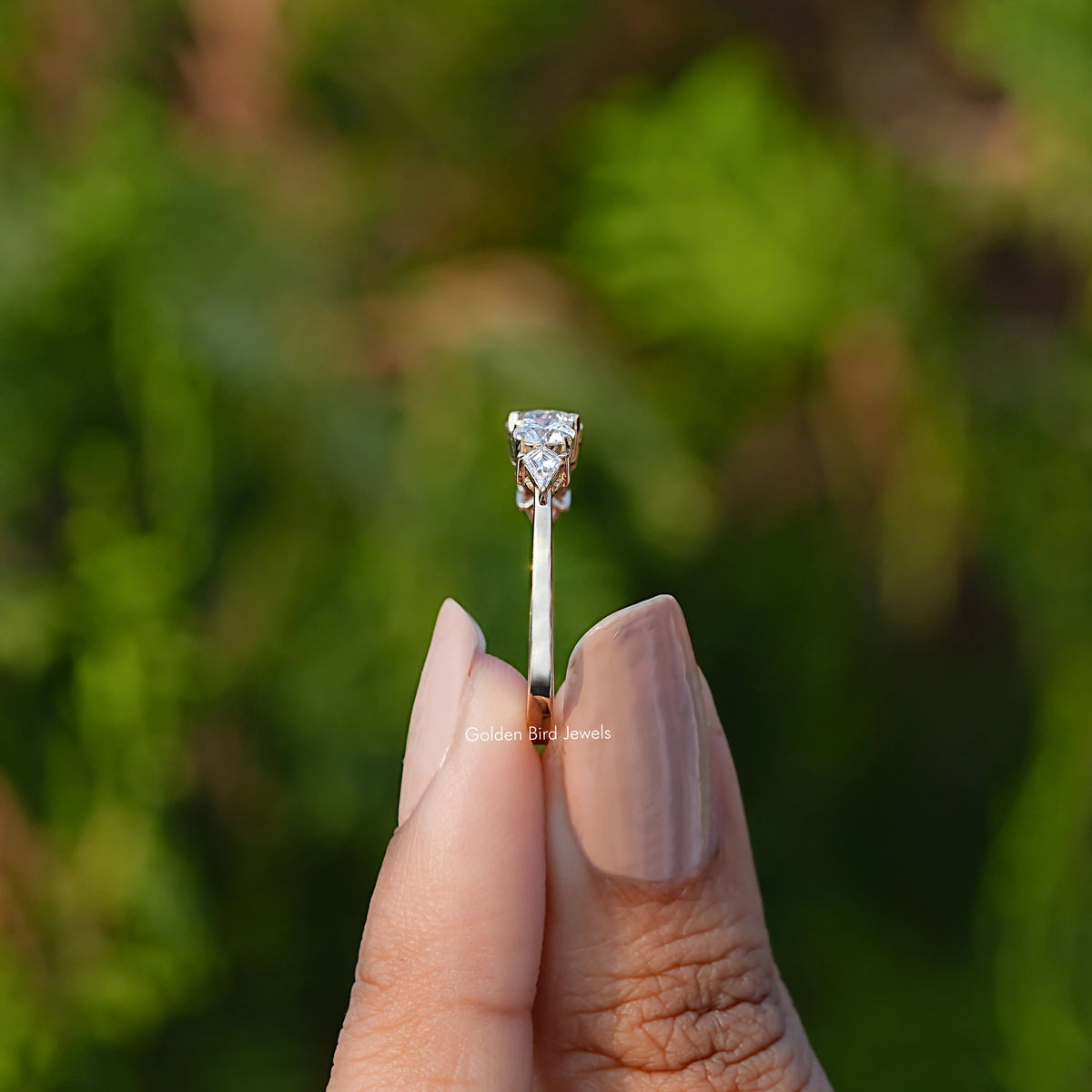 Side View of Kite And Round Cut Five Stone Ring In two fingers
