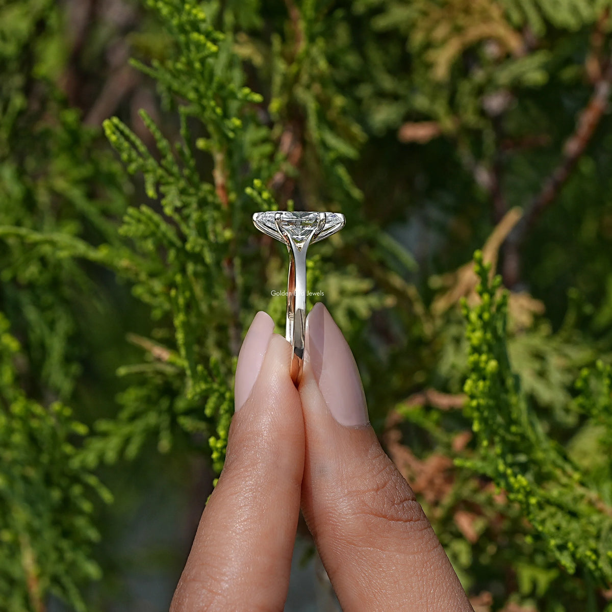 Side View of Marquise Cut Diamond Solitaire Engagement Ring In two fingers