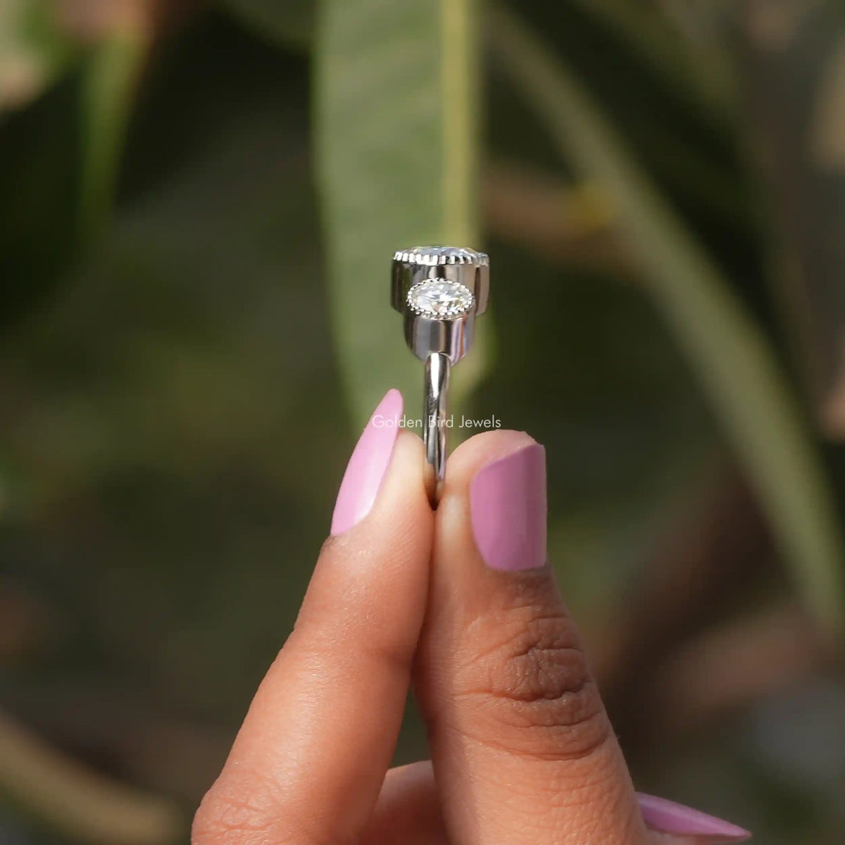 Side View of Bezel Set Round Cut Moissanite Ring In two fingers