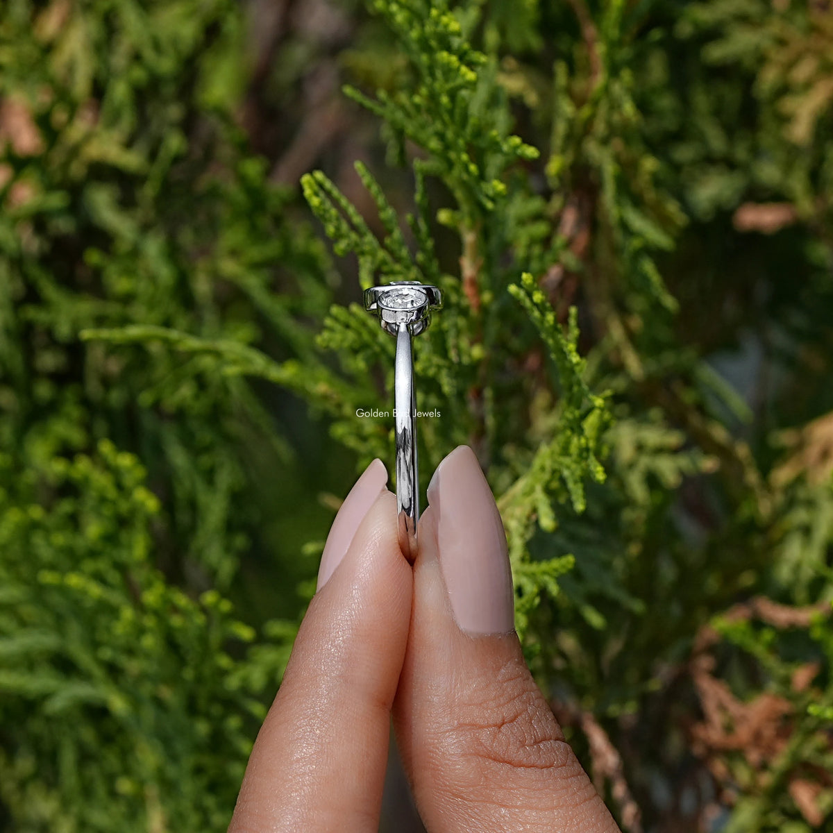 Side View of Round Cut Lab Diamond Three Stone Ring In two fingers