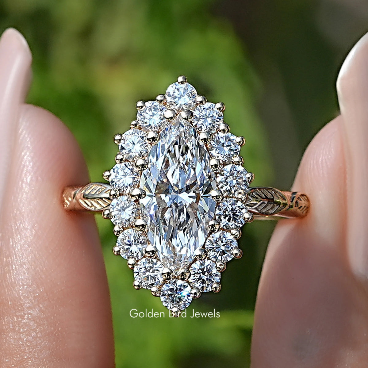 Marquise Cut Lab Diamond Halo Engagement Ring Held  Between Fingers