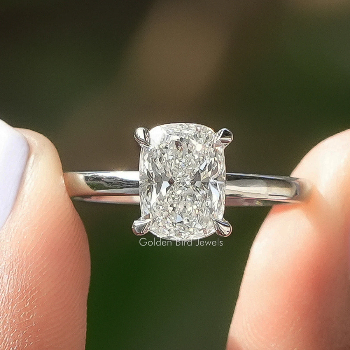 Cushion Cut Lab Grown Diamond Solitaire Ring Held Between Fingers