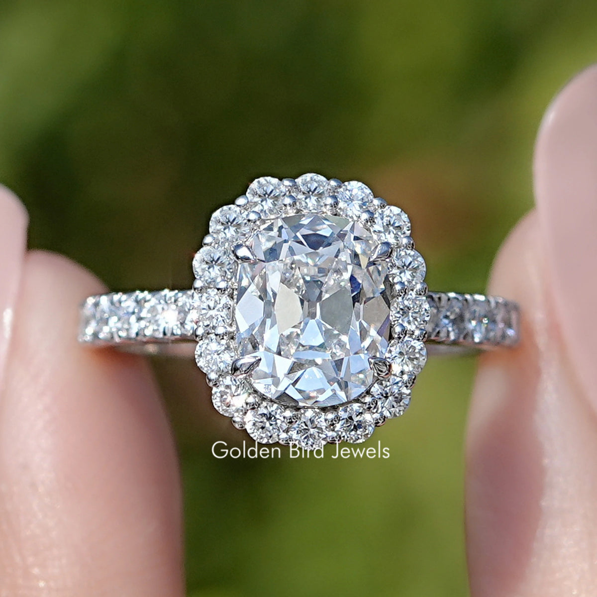 Front view of Old Mine Cushion Cut Lab Diamond Halo Ring in two fingers