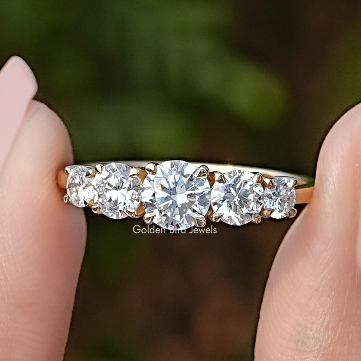 Lab Diamond Round Five Stone Accent Ring Held Between Fingers