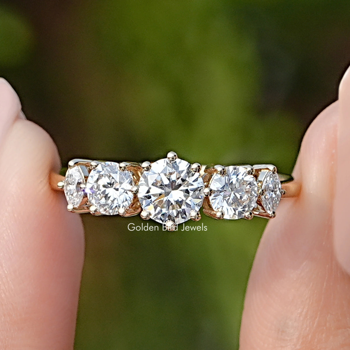 Five Stone Round Lab Diamond Accent Ring Held Between Fingers