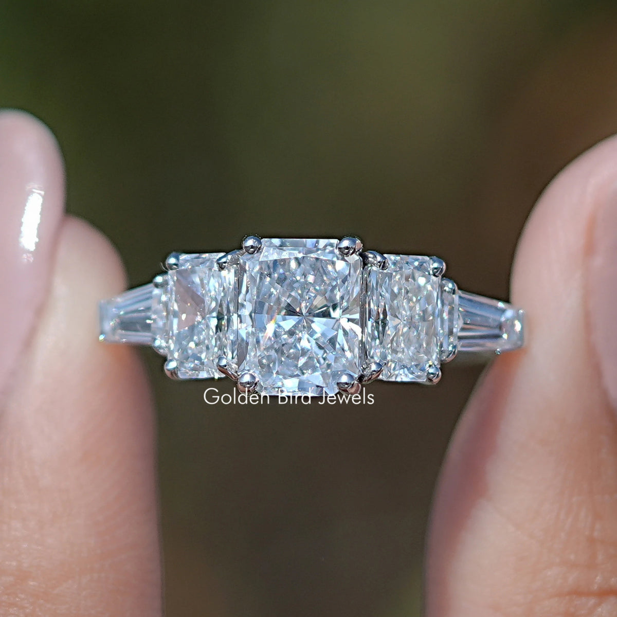 Radiant Cut Lab Diamond Five Stone Ring Held Between Fingers
