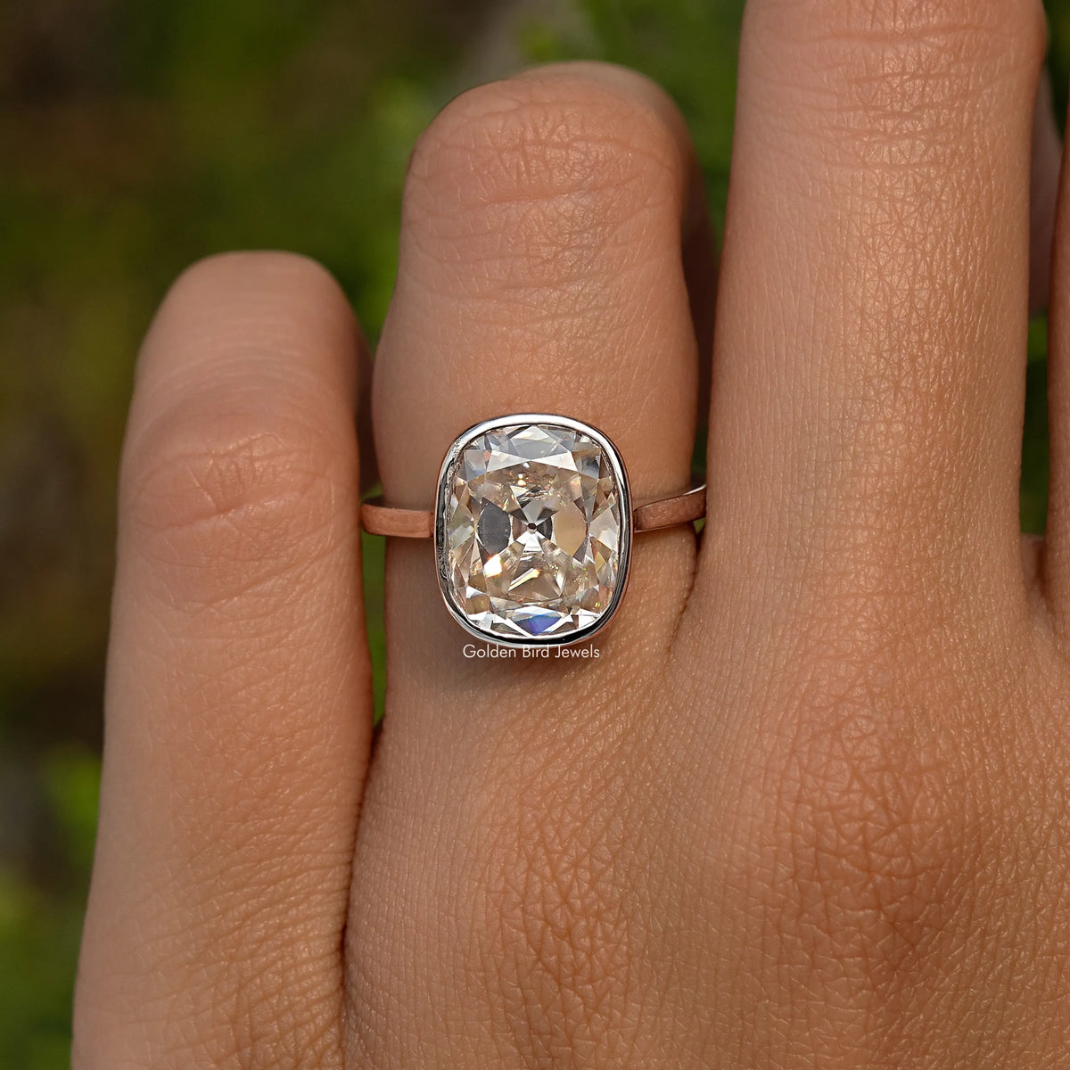 Sterling silver elongated cushion moissanite ring on hand with bezel-set cushion stone