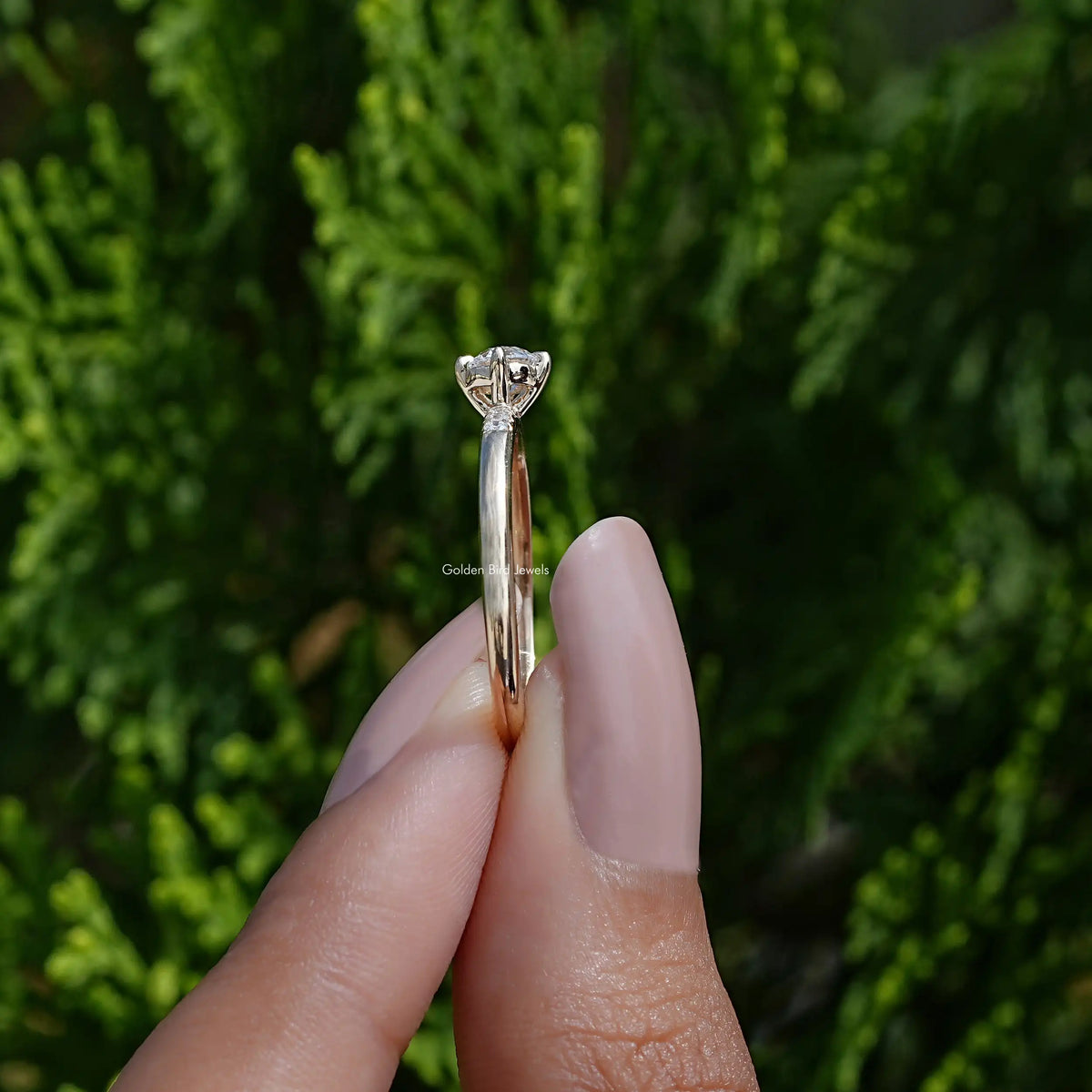 Side View of A Round Cut Lab Diamond Accent Ring In two fingers