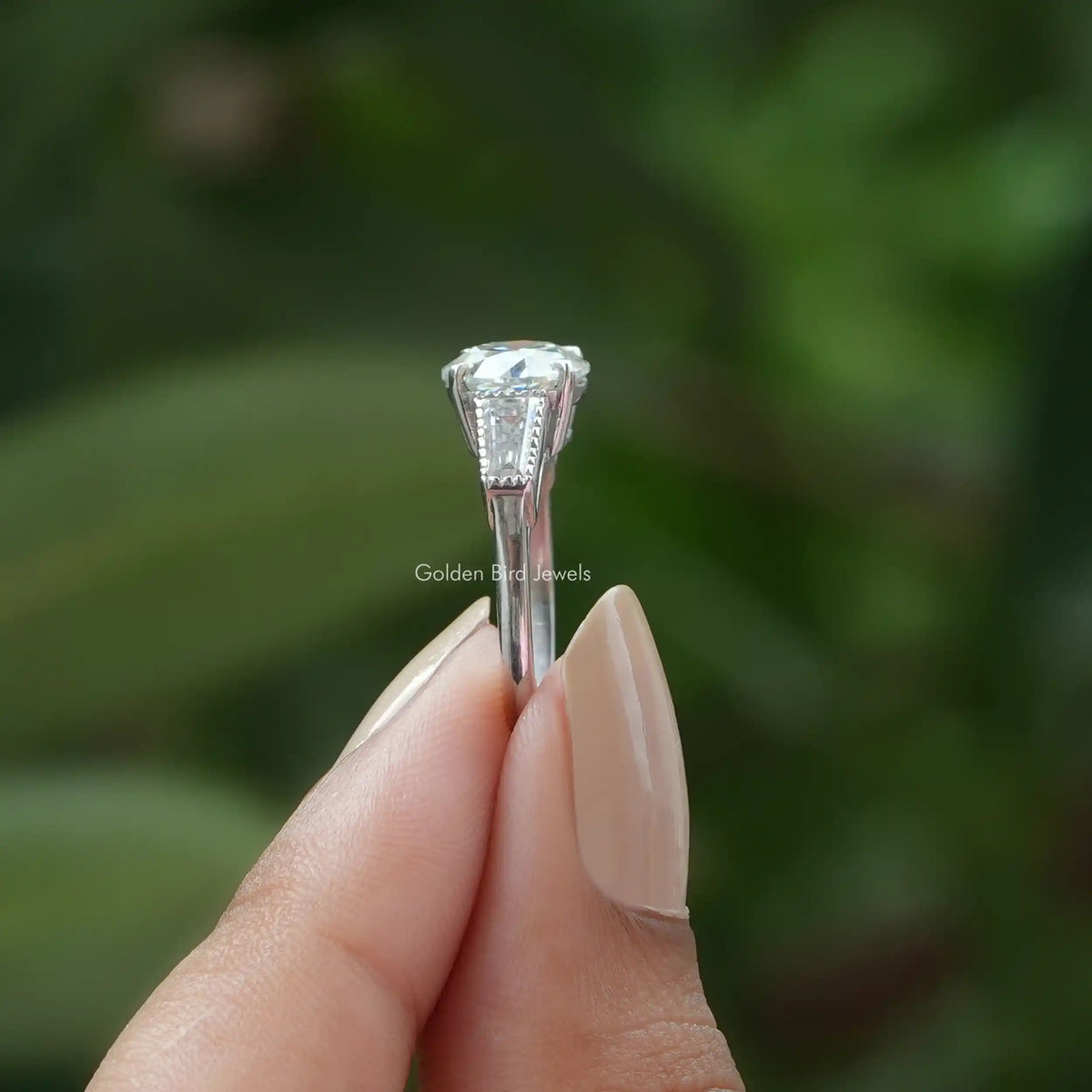 Side View of Old European Round Cut Three Stone Moissanite Ring In two fingers