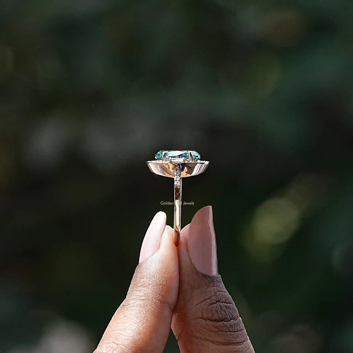 Side View of Oval And Baguette Cut Moissanite Halo Ring In two fingers