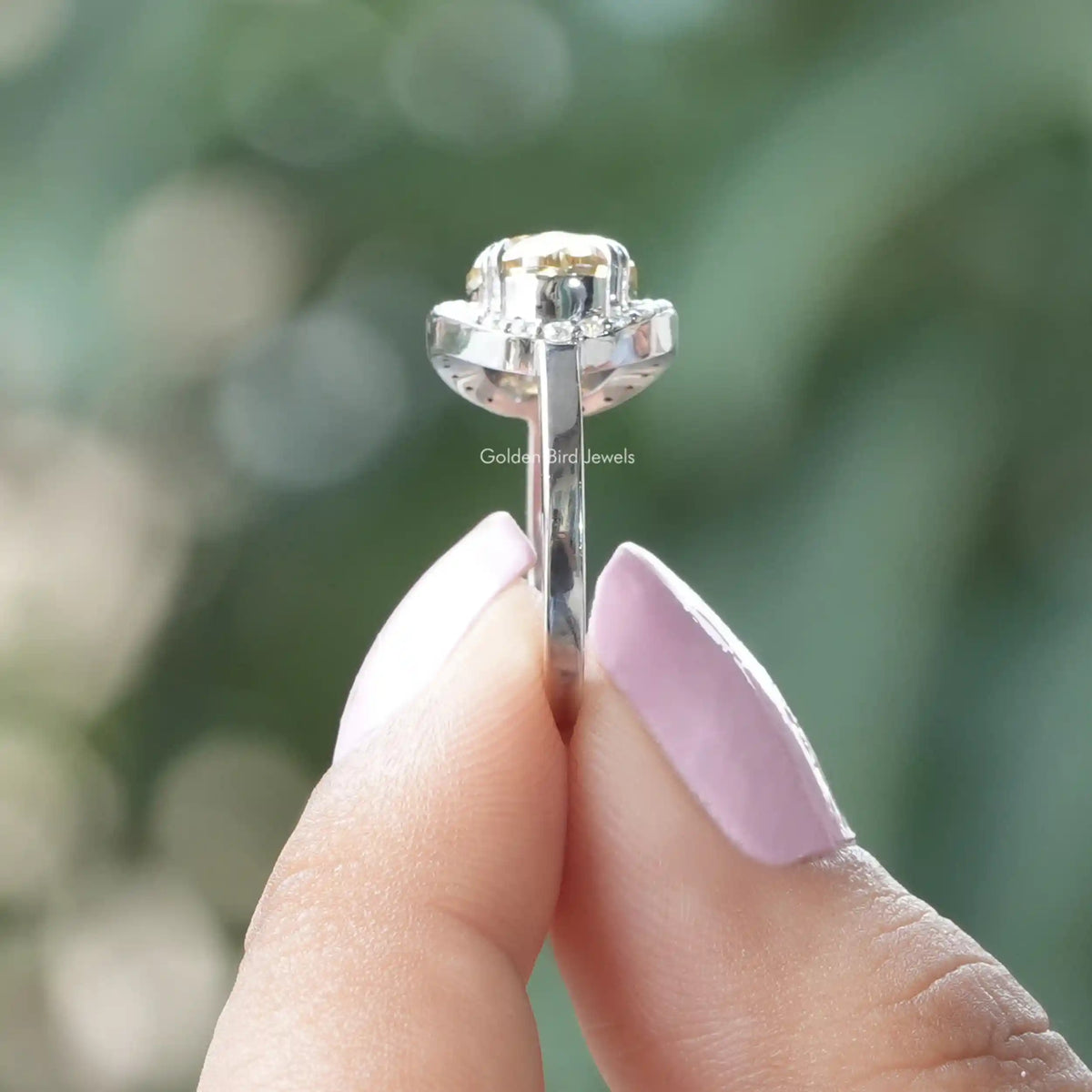 Side View of Moissanite Old Mine Oval Cut Halo Ring In two fingers