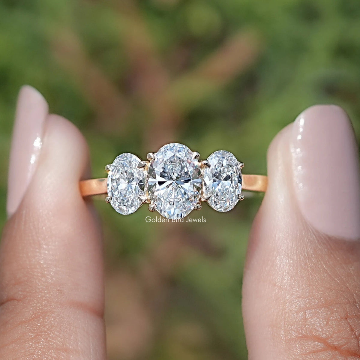 Oval Cut Lab Diamond Three Stone Engagement Ring In Two Fingers