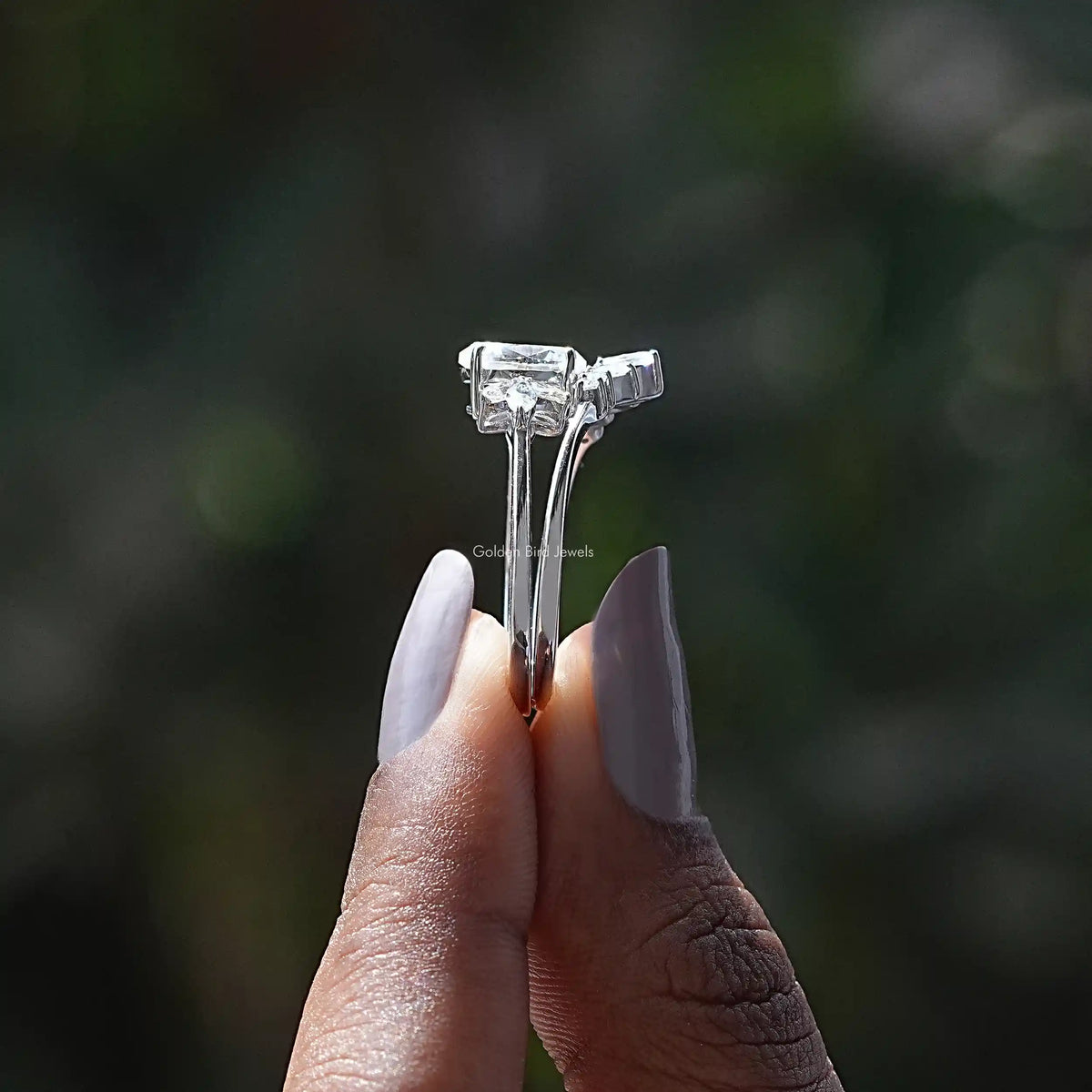 Side View of Oval And Pear Cut Moissanite Ring In two fingers