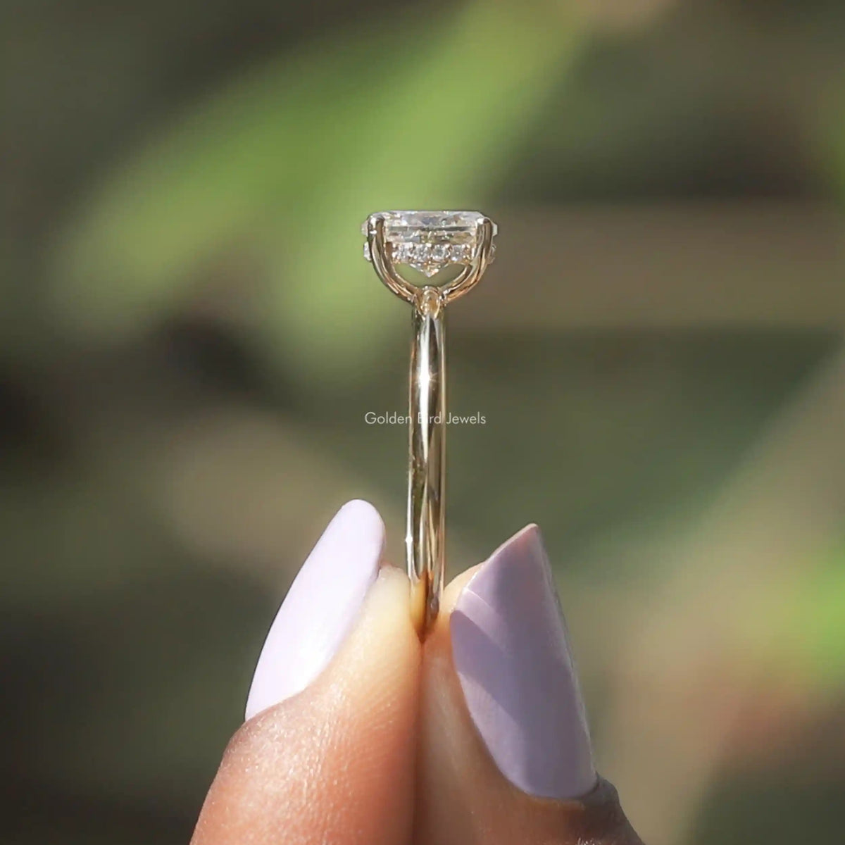 Side View of Oval Cut Moissanite Halo Ring In two fingers
