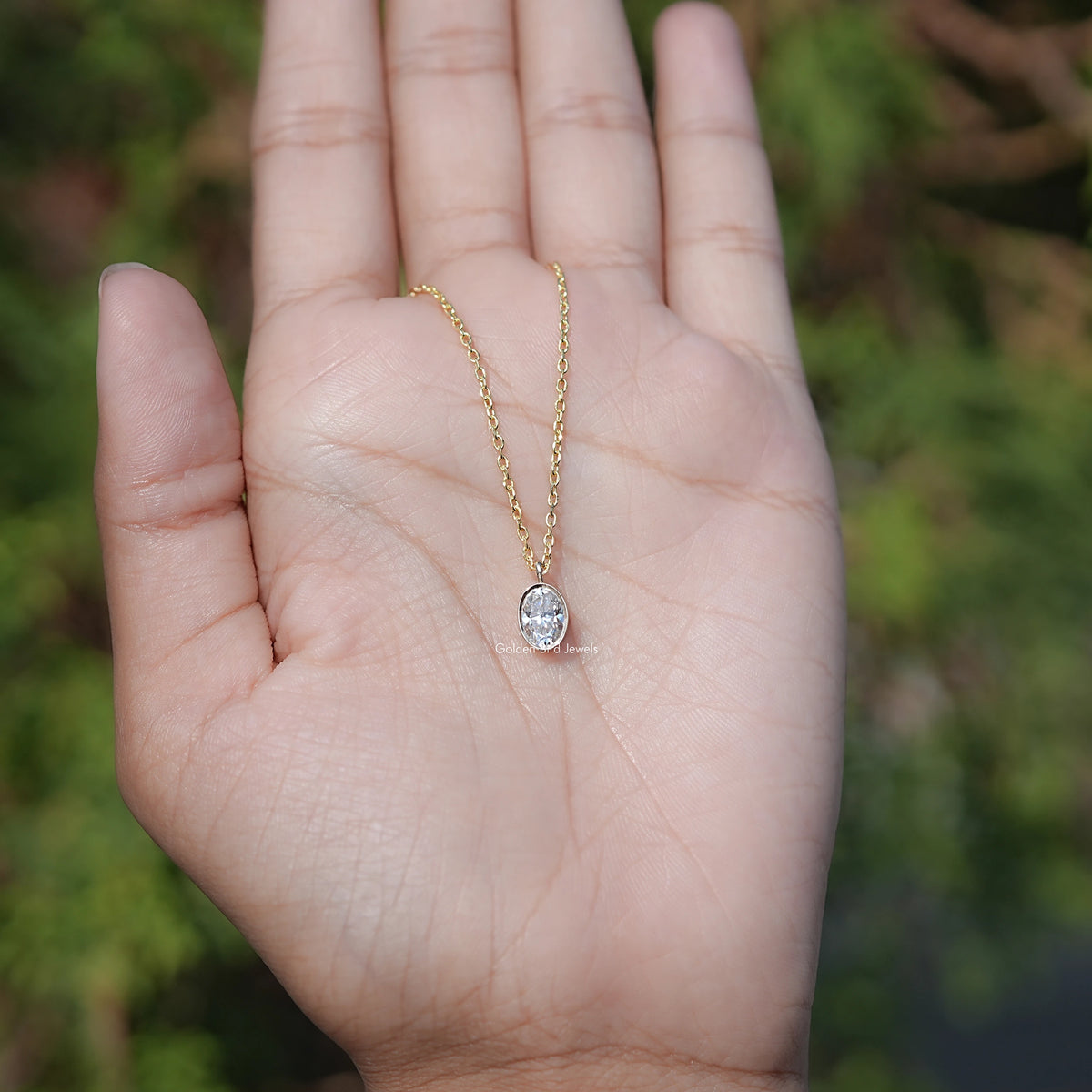 In hand Showing View Of Oval Cut solitaire pendant