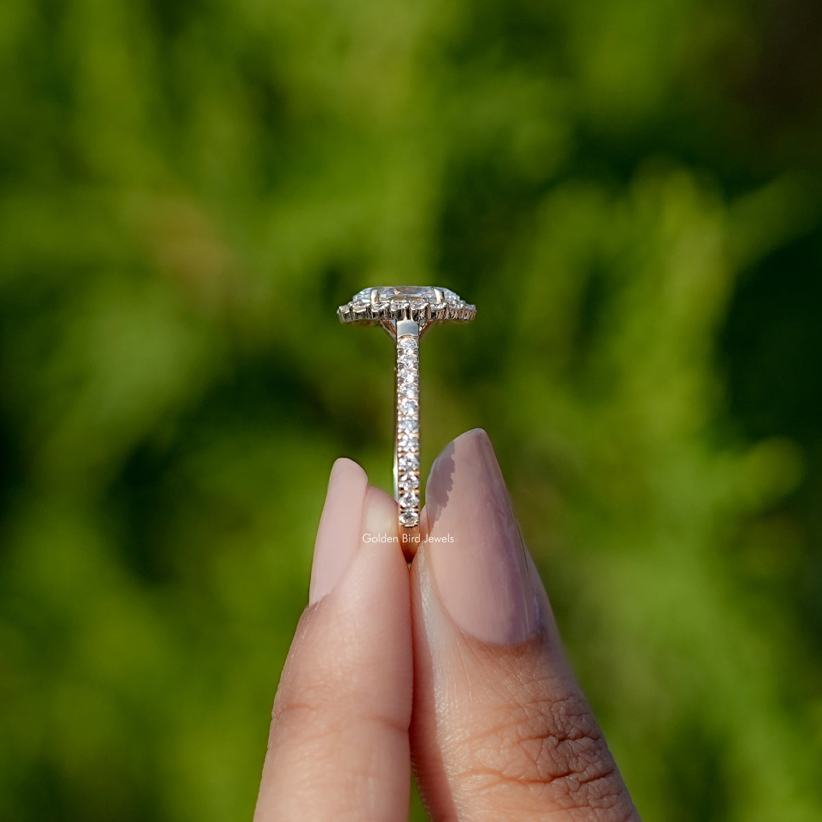 Side View of Oval Cut Lab Diamond Halo Engagement Ring In two fingers