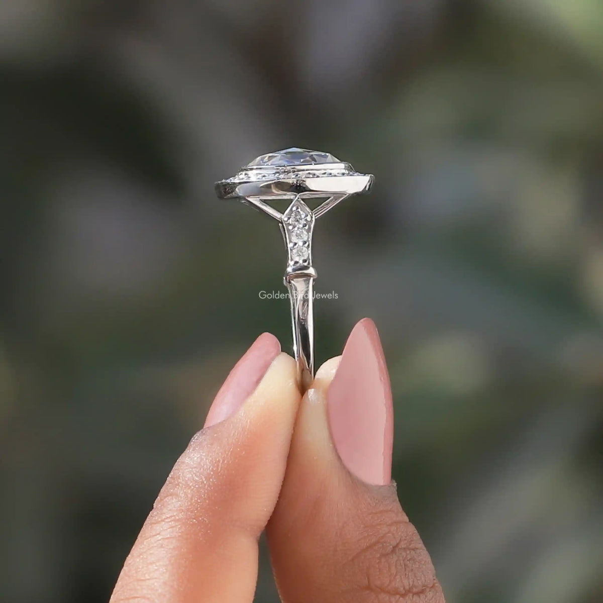 Side View of Oval Cut Moissanite Halo Engagement Ring In two fingers