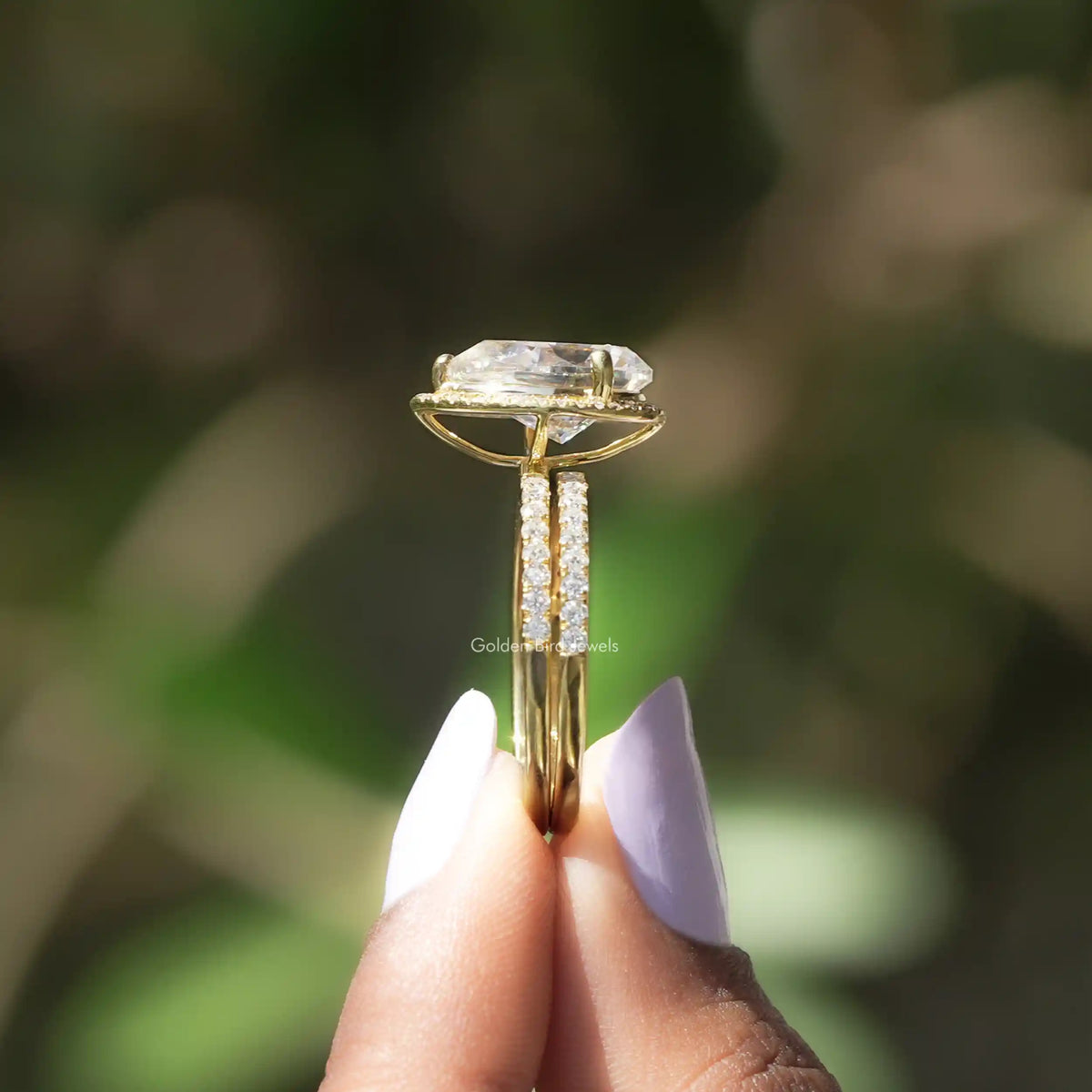 Side View of Pear Cut Moissanite Halo Ring In two fingers