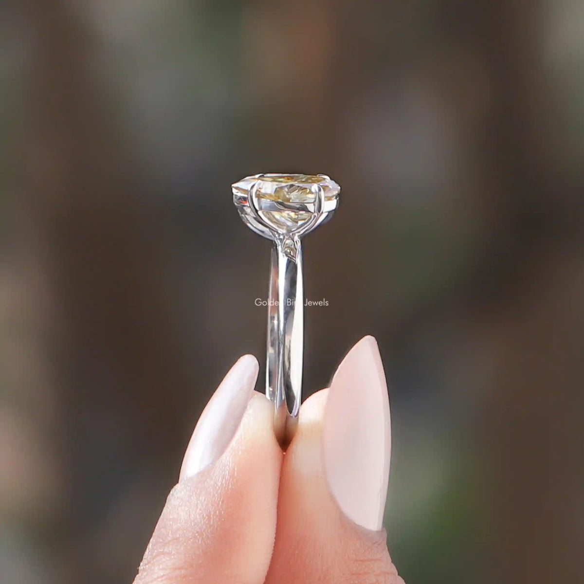 Side View of Pear Cut Toi Et Moi Bridal Ring In two fingers