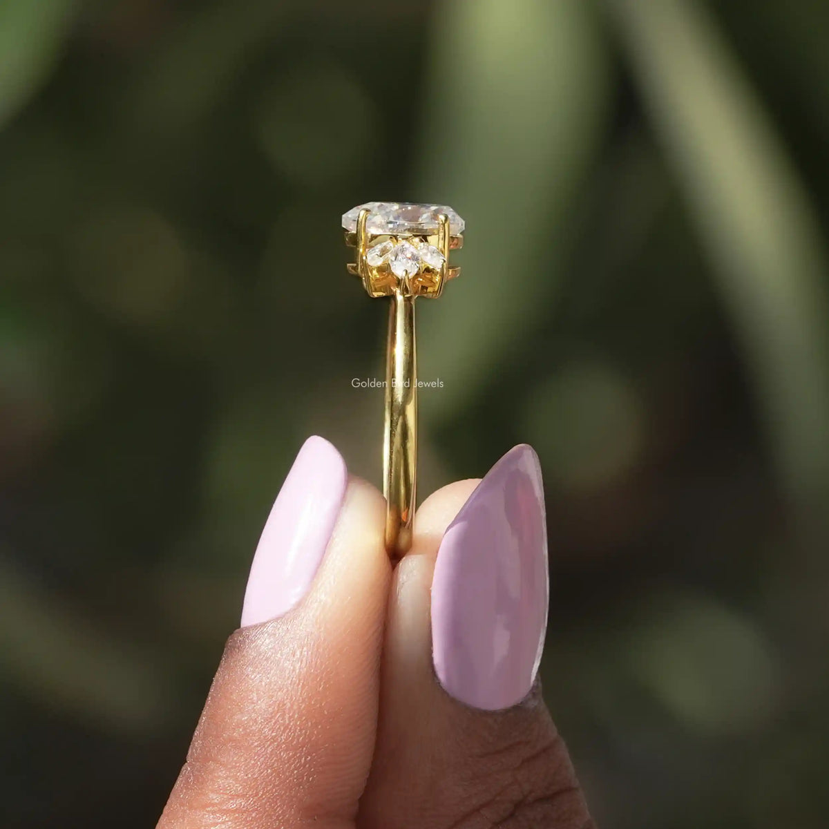 Side View of Pear And Marquise Cut Moissanite Ring In two fingers