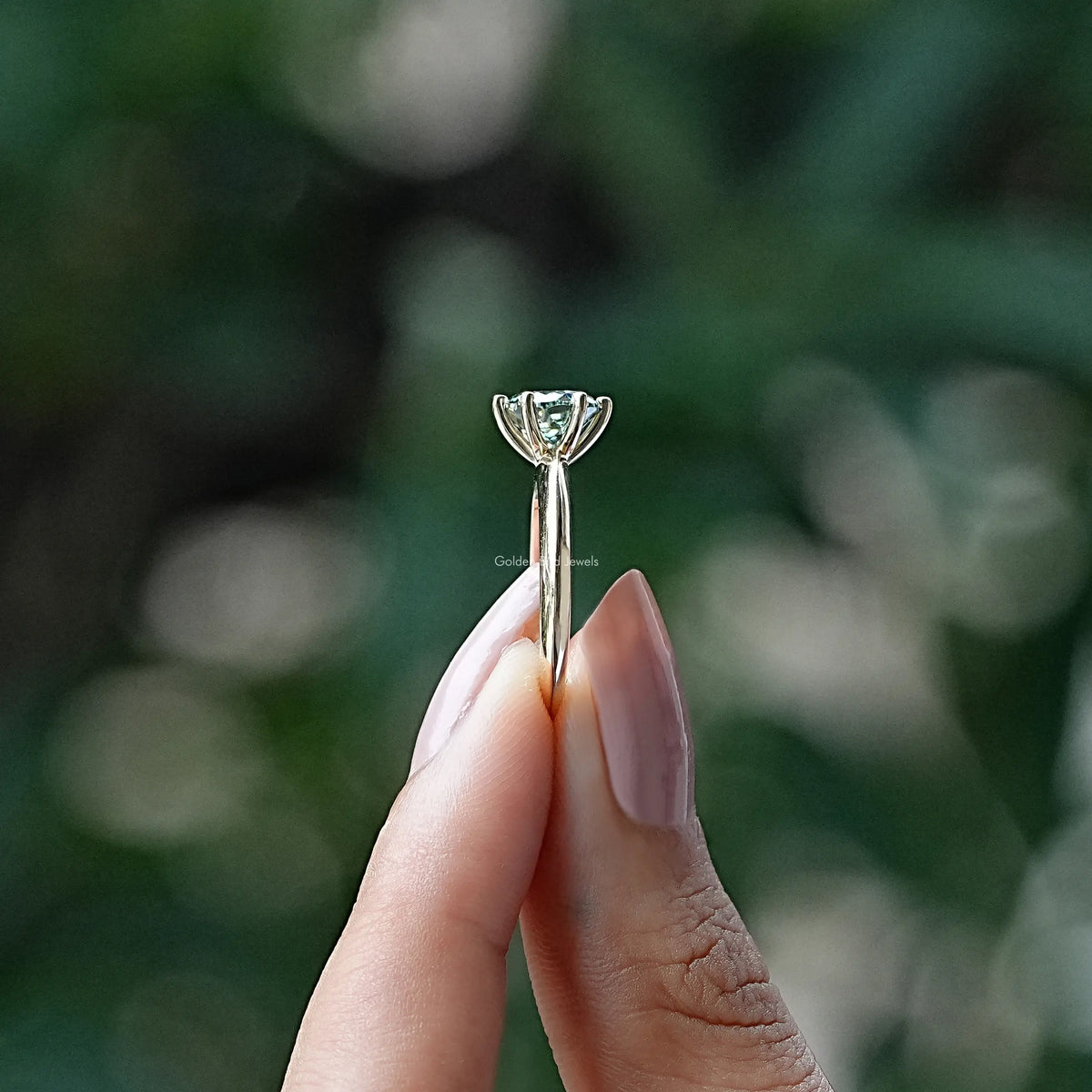 Side View of Portuguese Round Cut Engagement Ring In two fingers
