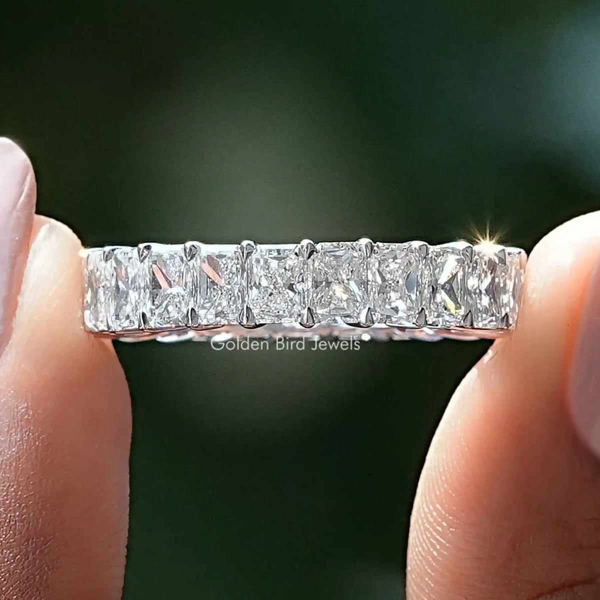 Radiant Cut Lab Diamond Eternity Band Held Between Fingers
