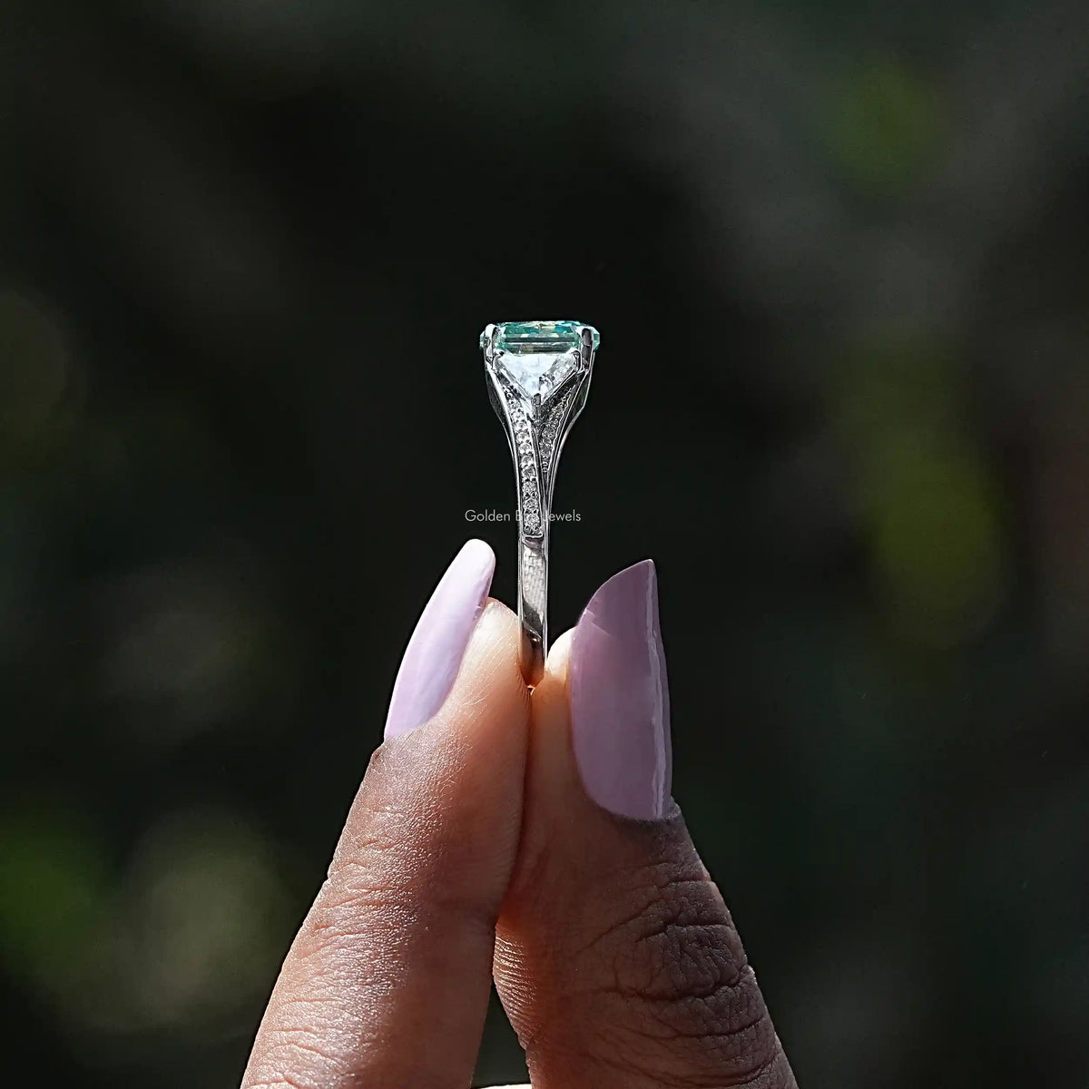 Side View of Radiant Cut Moissanite Accent Stone Ring In two fingers