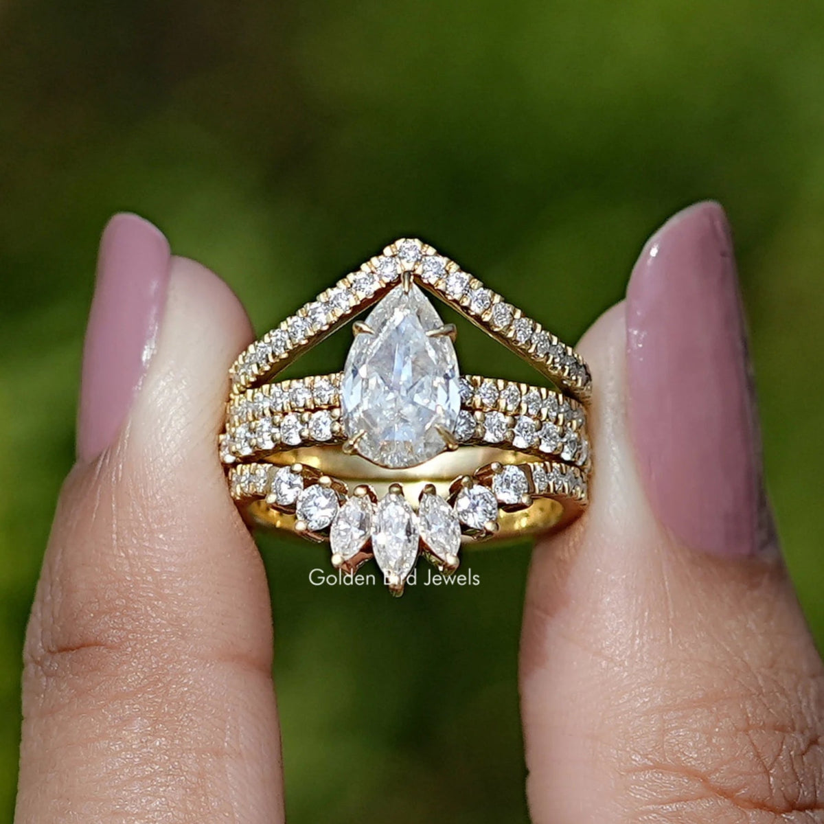 Two fingers holding the Rose Cut Pear Moissanite Bridal Ring