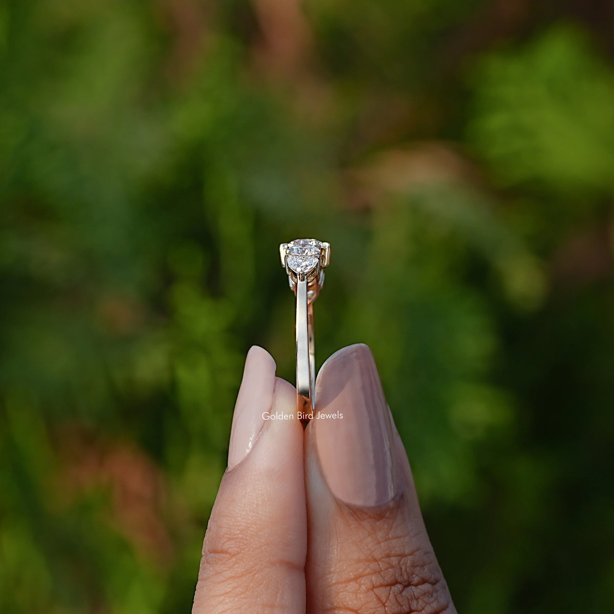 Side View of Round And Heart Cut Lab Diamond Ring In two fingers
