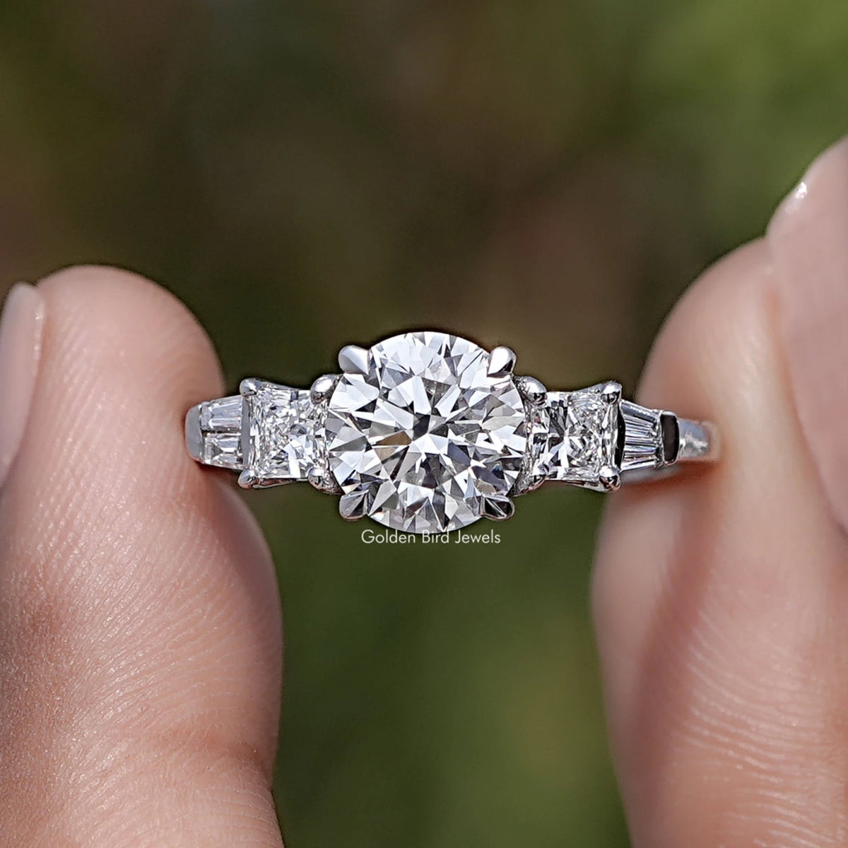 Round And Princess Diamond Five Stone Ring Between Two Fingers