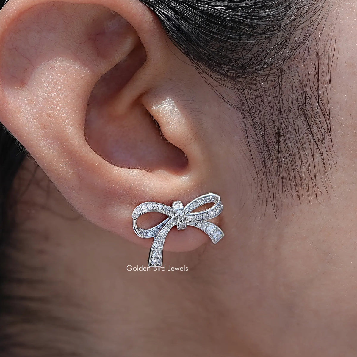 In Ear View Of Round Cut Lab Diamond Ribbon Bow Stud Earrings in prongs setting