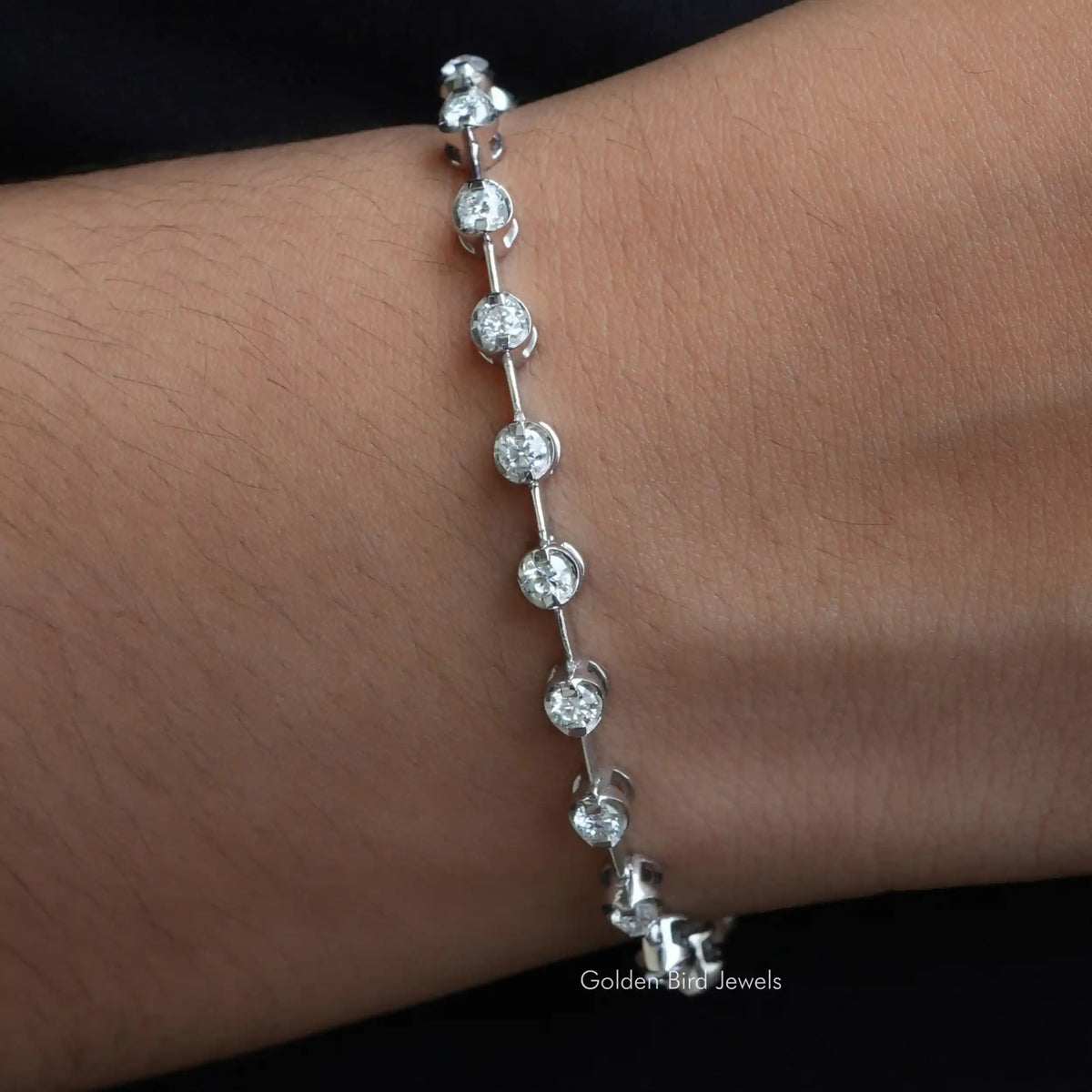 In hand front view of a round cut moissanite bangle bracelet