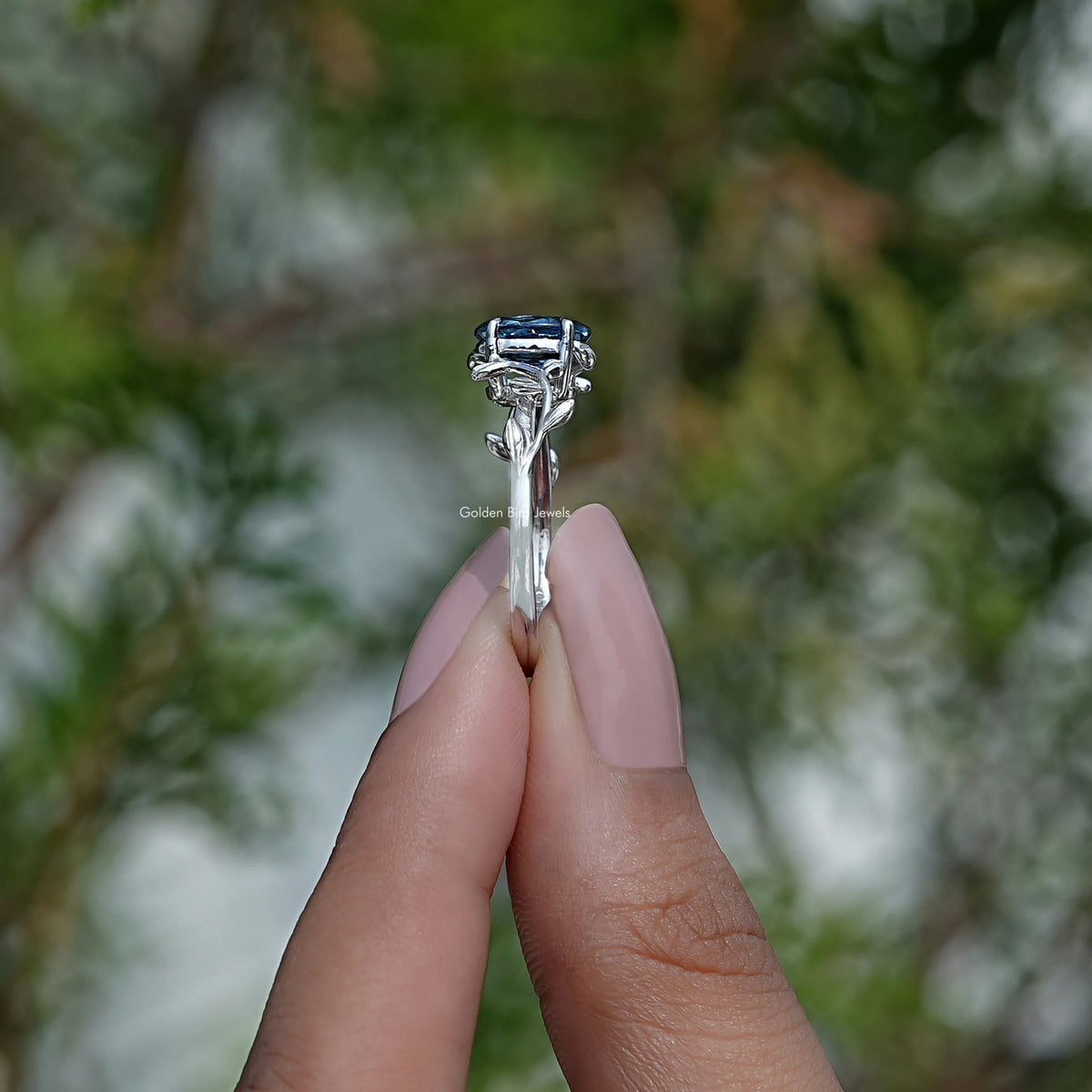 Side View of Blue Sapphire Oval Cut Ring In two fingers