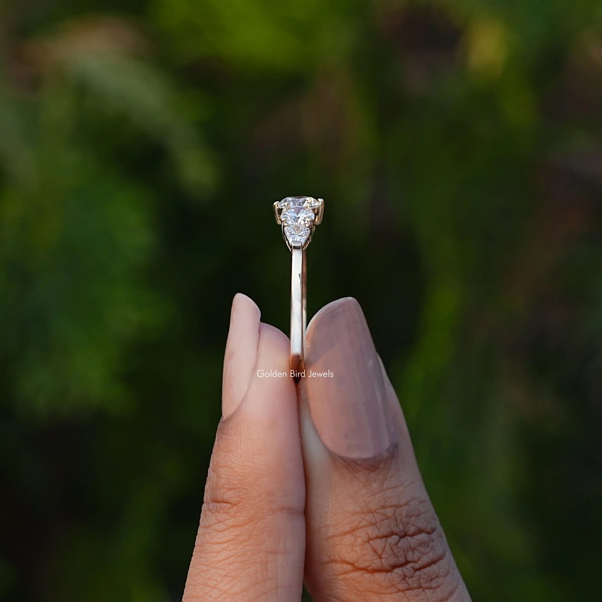Side View of Shield And Round Cut Lab Diamond Ring In two fingers
